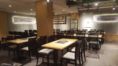 휴 한식당 매장 내부 — 식탁과 HYU Restaurant 간판