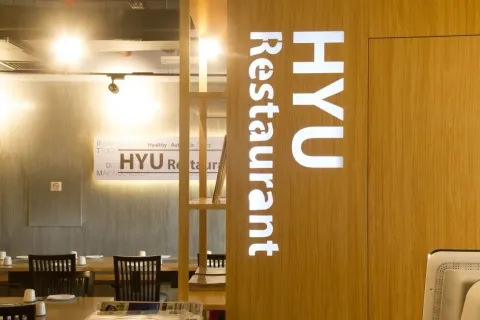 휴 한식당 목재 가림막과 HYU Restaurant 간판